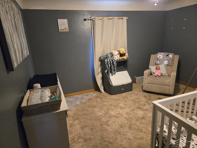 carpeted bedroom with a crib and baseboards