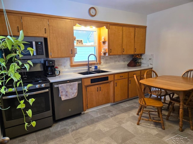 kitchen featuring a sink, light countertops, appliances with stainless steel finishes, decorative backsplash, and brown cabinets