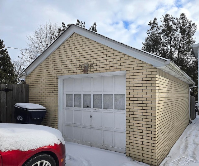 detached garage featuring driveway and fence