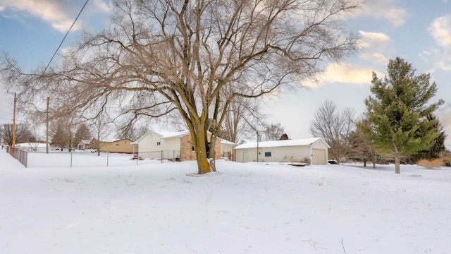 yard layered in snow with an outdoor structure and a garage