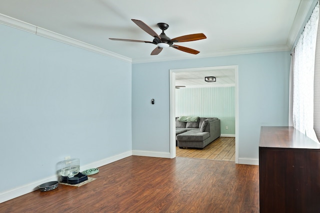 spare room featuring baseboards, ceiling fan, wood finished floors, and crown molding