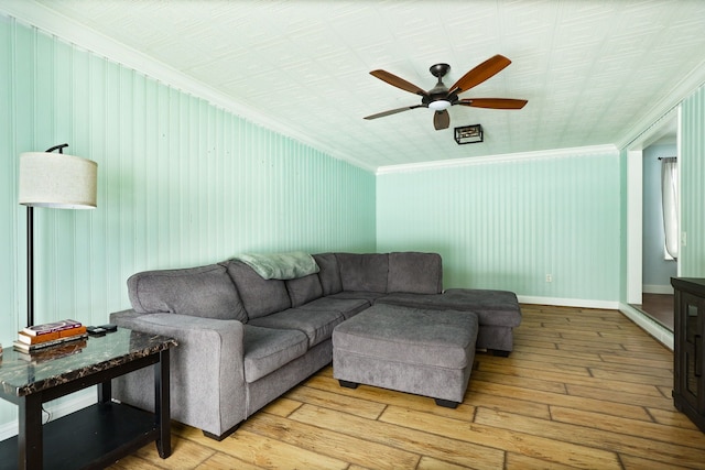 living area featuring light wood-style floors, ornamental molding, baseboards, and ceiling fan