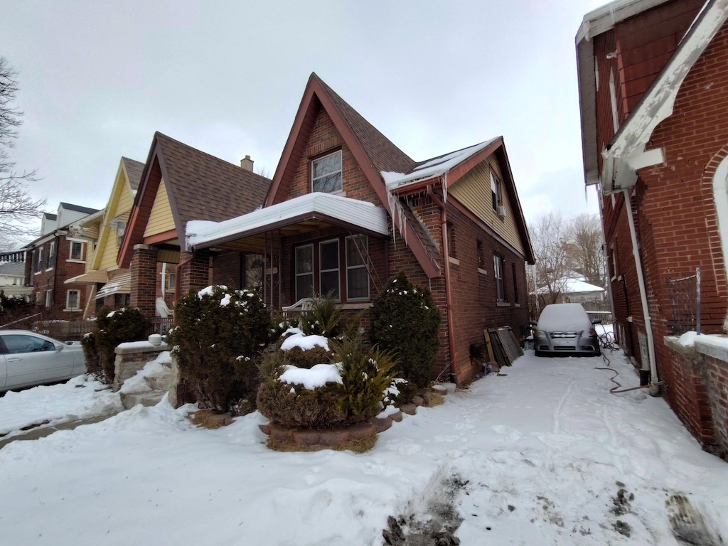 view of snowy exterior featuring brick siding