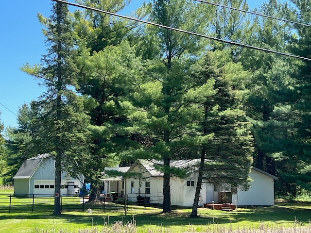 view of front of home featuring a garage, fence, an outdoor structure, and a front yard