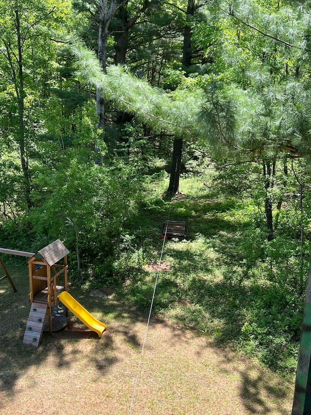 view of jungle gym featuring a wooded view