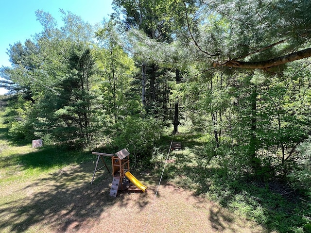 view of yard with a forest view and a playground