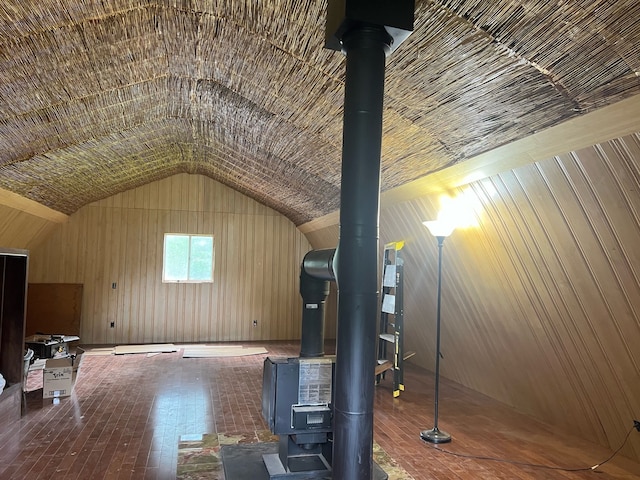 bonus room featuring lofted ceiling and a wood stove