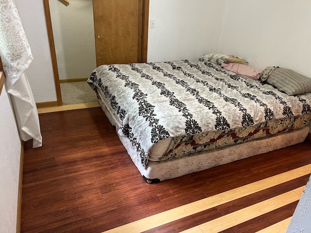 bedroom with baseboards and wood finished floors