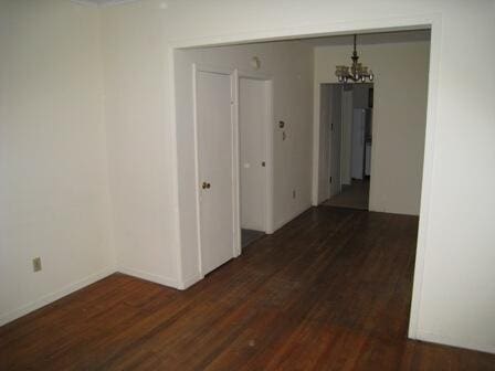 hallway featuring a notable chandelier and wood finished floors