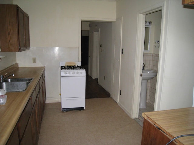 kitchen featuring tile walls, wooden counters, a sink, and white gas stove