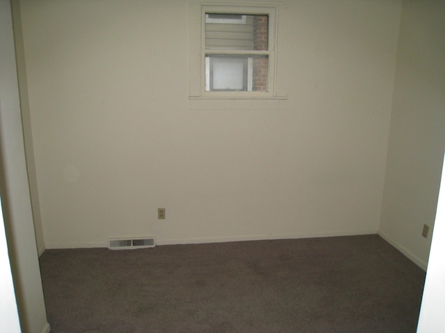 carpeted spare room with visible vents and baseboards