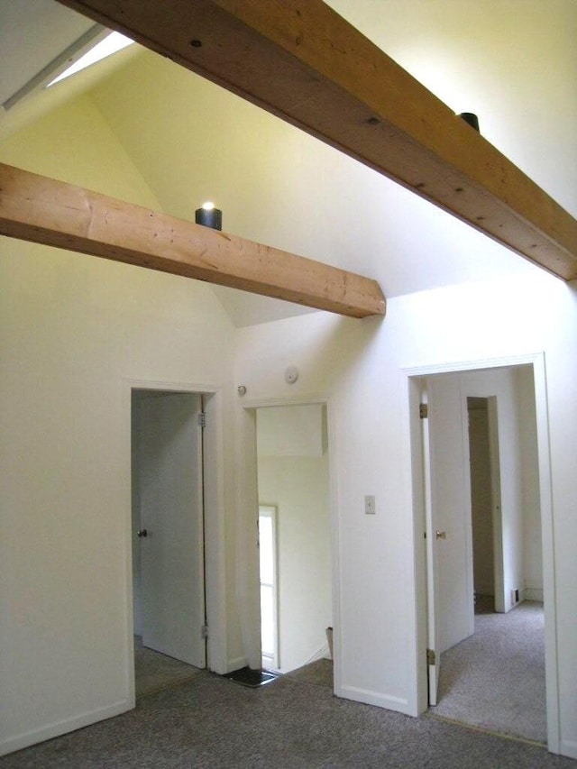 carpeted spare room with lofted ceiling with beams