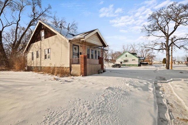 view of side of home featuring covered porch