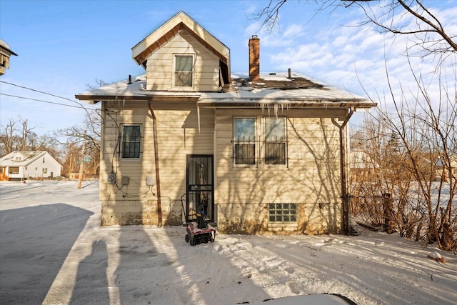 back of house with a chimney