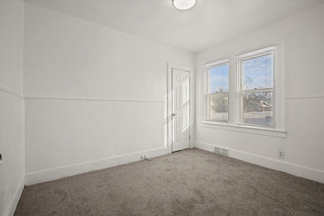 carpeted empty room with visible vents and baseboards