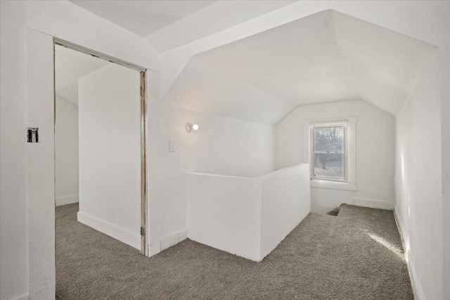 additional living space with carpet floors and vaulted ceiling