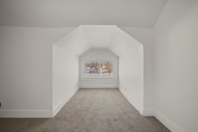 additional living space featuring carpet floors, lofted ceiling, and baseboards