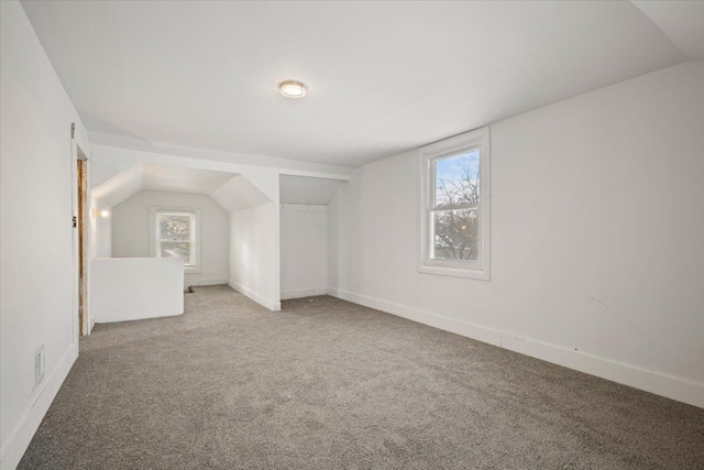 bonus room featuring lofted ceiling, carpet, and baseboards