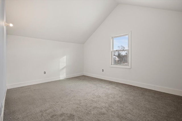 additional living space featuring carpet, vaulted ceiling, and baseboards