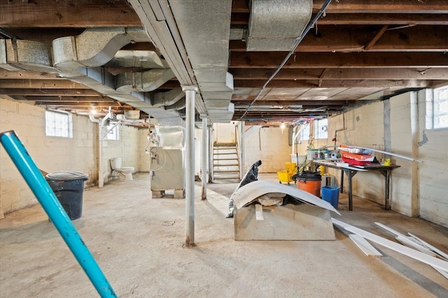 basement with stairs and heating unit