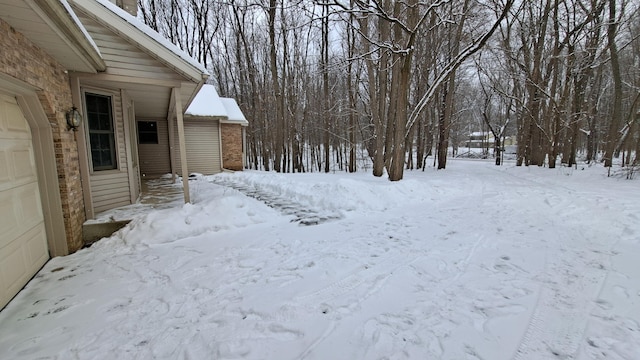 yard covered in snow featuring a garage