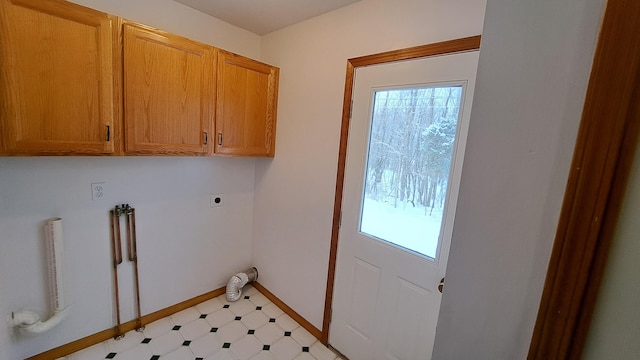 laundry room with plenty of natural light, light floors, cabinet space, and electric dryer hookup