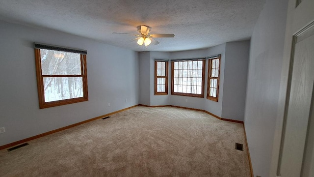 empty room featuring light carpet, baseboards, and visible vents