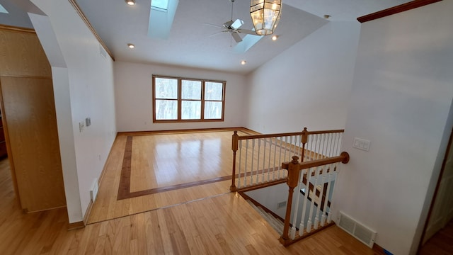 bonus room featuring ceiling fan, high vaulted ceiling, a skylight, visible vents, and light wood-type flooring