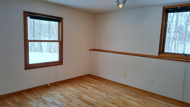 unfurnished room featuring light wood-type flooring and baseboards