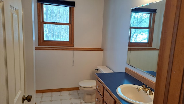 bathroom with baseboards, vanity, toilet, and tile patterned floors