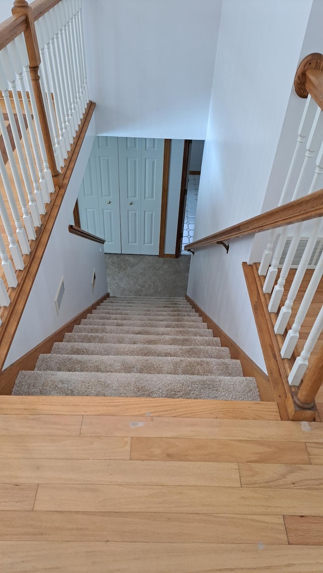 stairway with carpet, visible vents, and baseboards