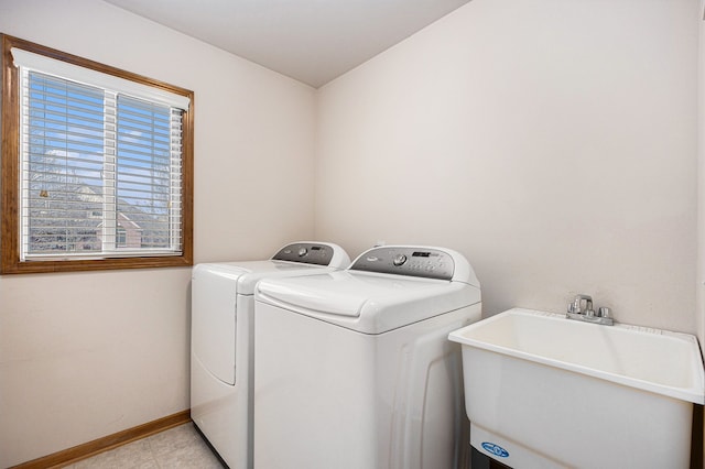 laundry room with laundry area, a sink, baseboards, and separate washer and dryer