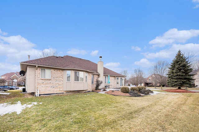 rear view of property with a lawn and a chimney