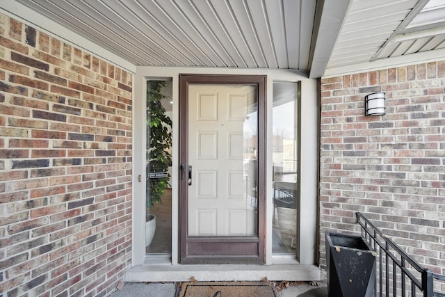 view of exterior entry with brick siding