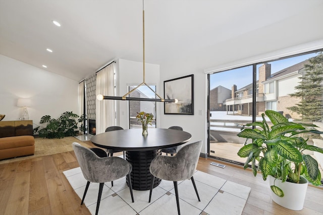 dining room featuring light wood-style floors, recessed lighting, visible vents, and vaulted ceiling