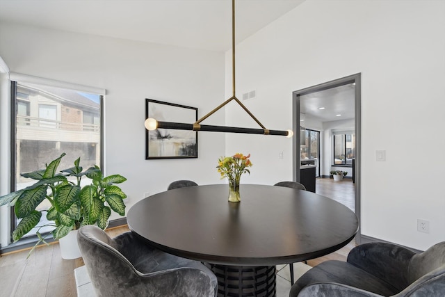 dining space with visible vents, a wealth of natural light, and wood finished floors