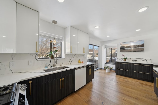 kitchen with a sink, white cabinets, dishwasher, modern cabinets, and gas range