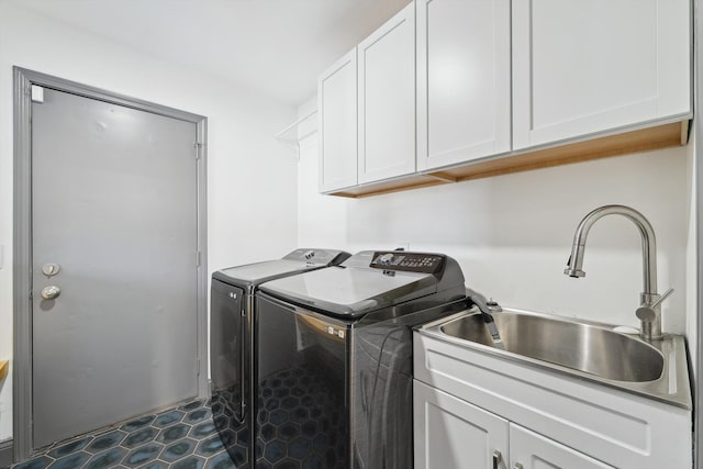 laundry area featuring cabinet space, washer and clothes dryer, and dark tile patterned floors