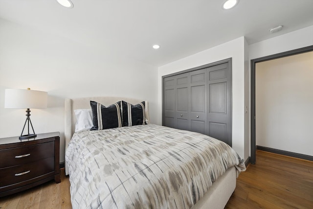 bedroom with baseboards, a closet, wood finished floors, and recessed lighting