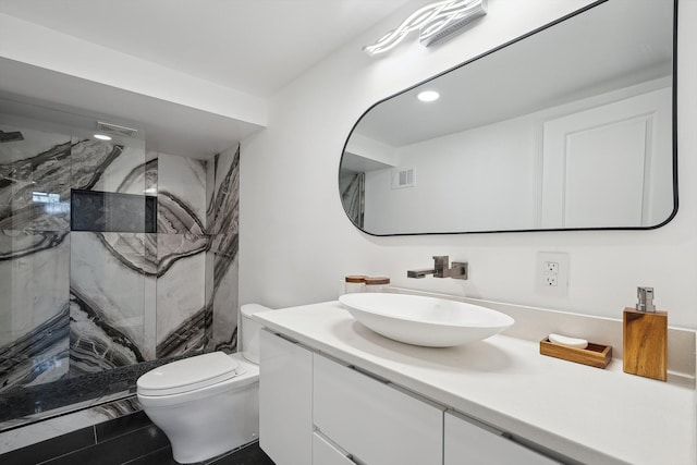 full bathroom featuring toilet, a marble finish shower, visible vents, and vanity