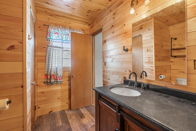 bathroom featuring wooden ceiling, wood walls, wood finished floors, and vanity