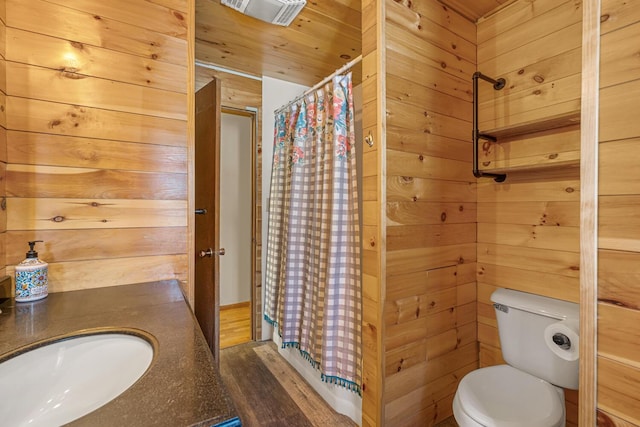 full bathroom featuring visible vents, a sink, and wooden walls