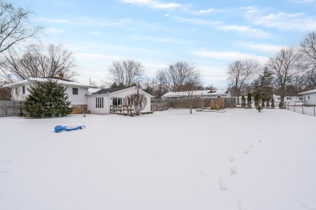 yard layered in snow featuring fence