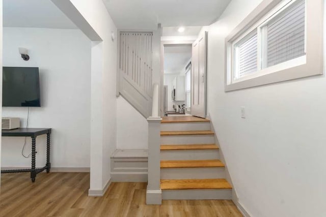 stairway featuring baseboards and wood finished floors