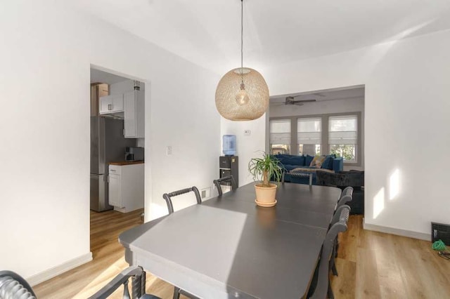 dining space featuring light wood-style flooring and baseboards