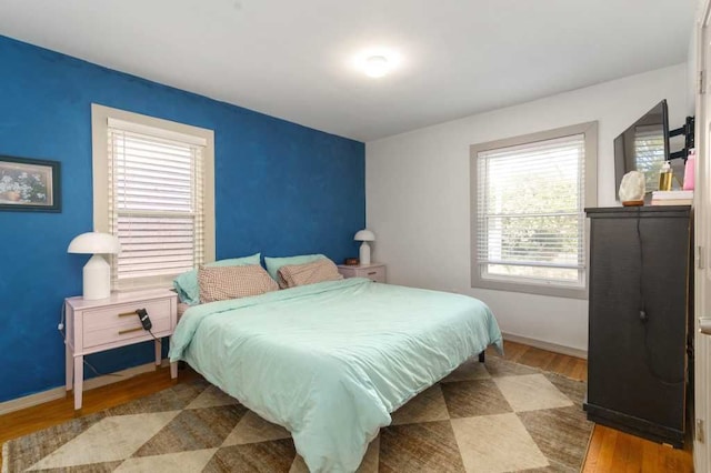 bedroom featuring wood finished floors and baseboards