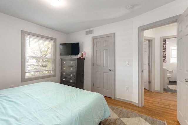 bedroom featuring baseboards, visible vents, and light wood-style floors