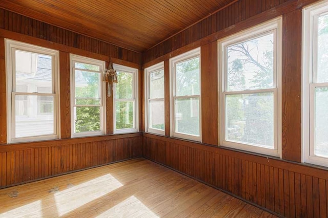 unfurnished sunroom with a healthy amount of sunlight and wood ceiling