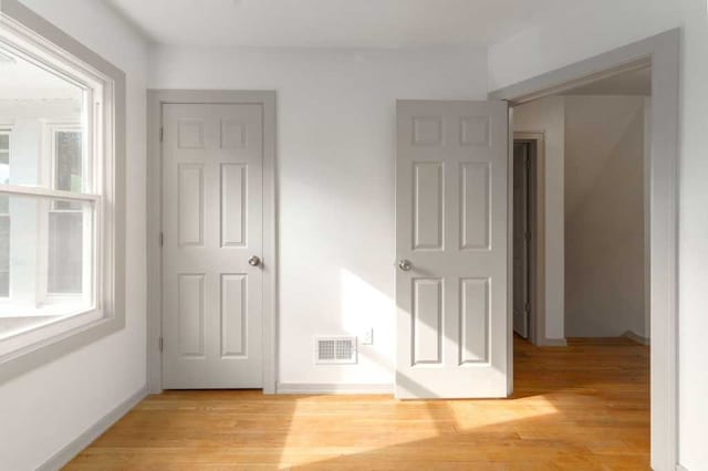 interior space featuring visible vents, a wealth of natural light, light wood-style flooring, and baseboards