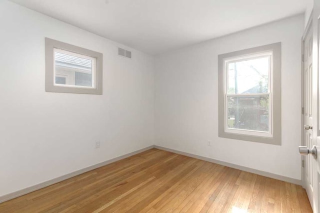 unfurnished room with baseboards, visible vents, and light wood finished floors